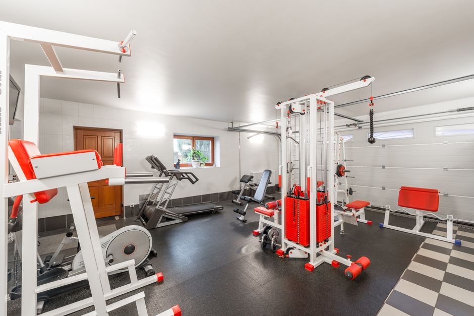 Inspirerende fitnessposter naast halters in huiselijke gym.